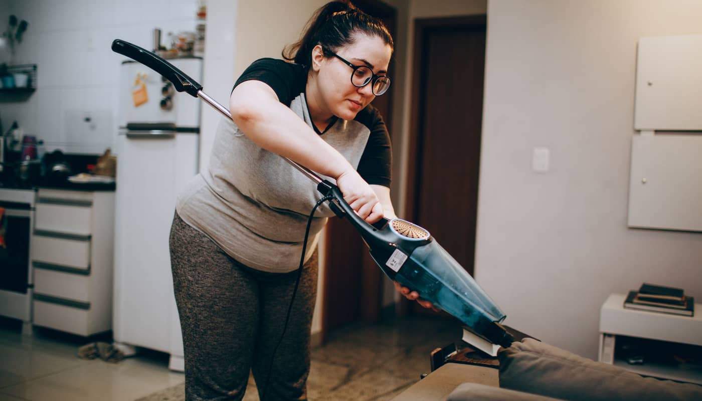 A couch being vacuumed in a living room