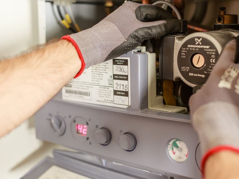Hands adjusting the controls on a water heater