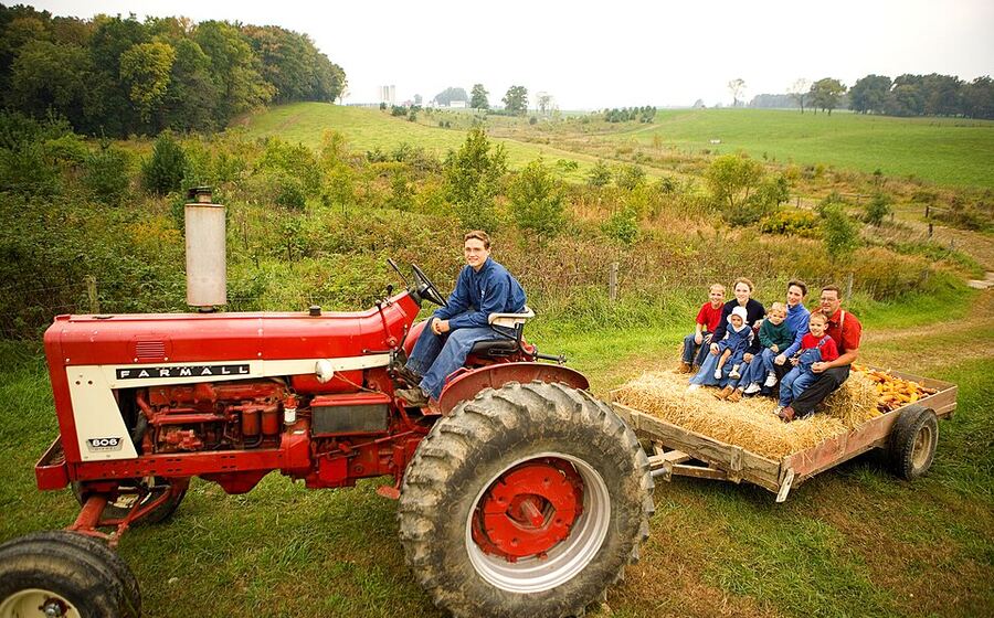 A tractor pulling a hay wagon with visitors at Mill Hollow Farm