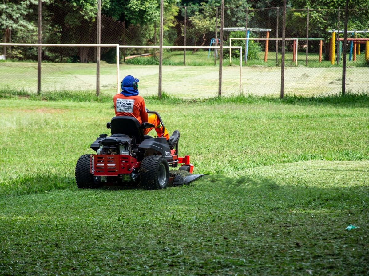Ride-on mower cutting a green lawn
